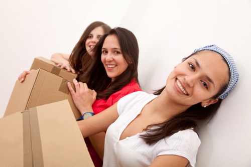 Professional movers carrying furniture through a local East London property